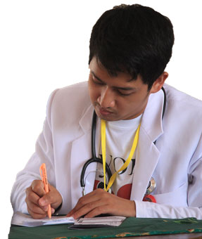 Pediatrician leans over paper with pen in hand while writing a letter of medical necessity