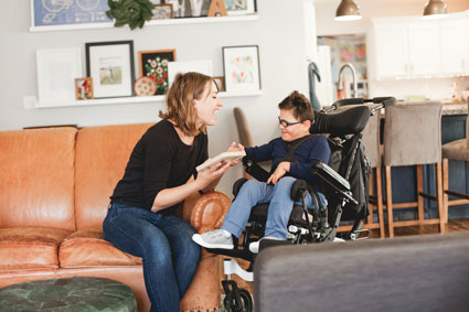 Mother reading to child with intellectual disability in wheelchair